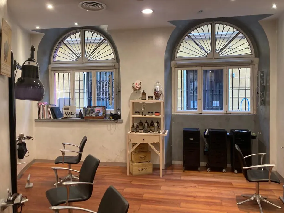 Interno del salone: poltrone, specchi e due grandi finestre ad arco